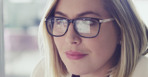 woman warning glasses that are reflecting from a computer screen